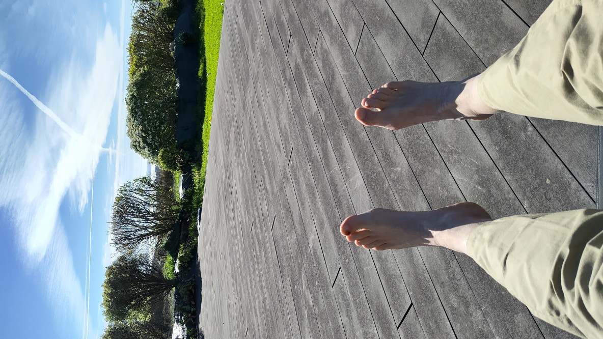 Füße auf Terrasse mit Blick zum Meer